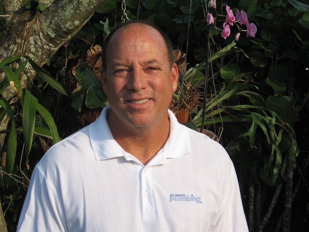 James Woolfe, owner of All Quality Plumbing, outside in a company shirt