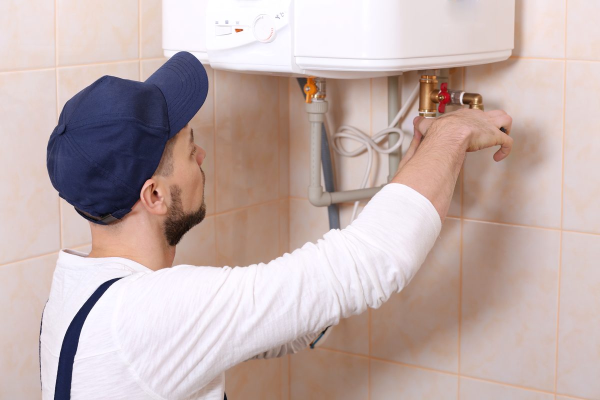 Plumber connecting the supply lines on a wall mounted water heater